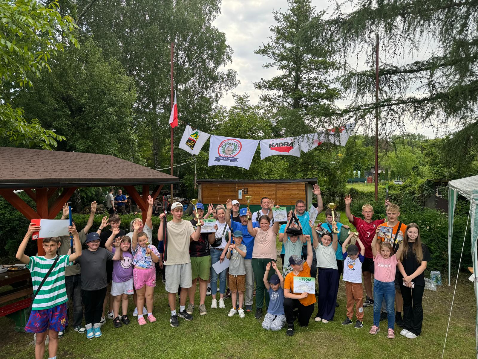 Uczesniczki i uczesnicy zawodów wędkarskich nad zbiornikiem Łan