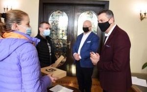 Prezydent Mariusz Wołosz i prezes PEC Henryk Dolewka wręczają w Urzędzie Stanu Cywolnego śpioszki rodzicom nowo narodzonych bliźniaczków 